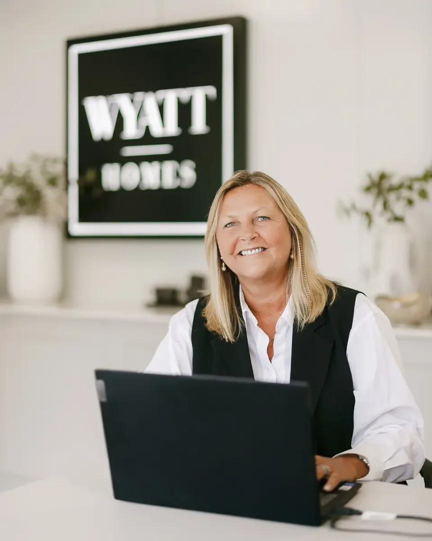 Branding photography in Bournemouth showing a smiling business owner working at a laptop in a modern office