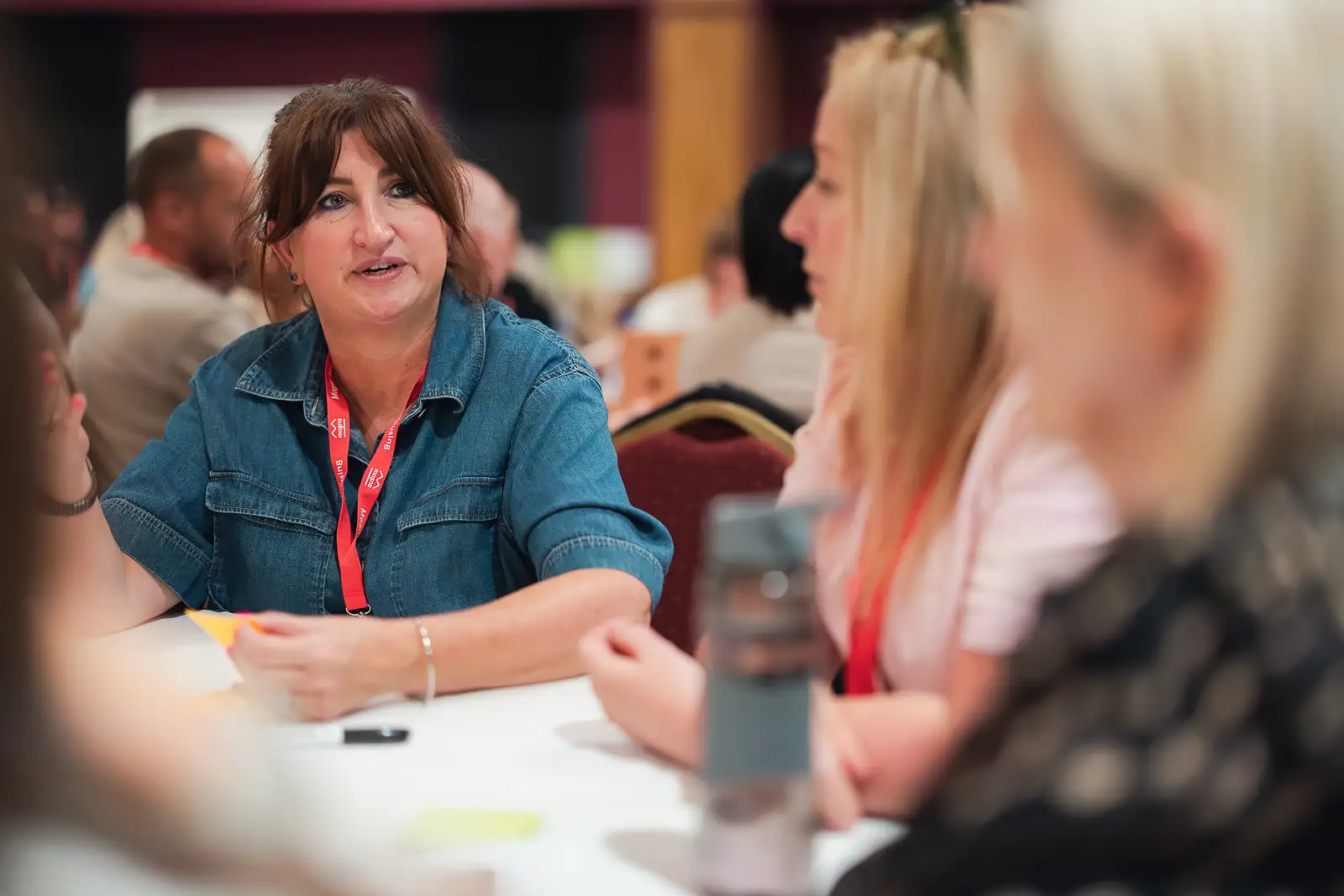 Female colleague engaged in group discussion at a round table during a corporate away day event in Somerset