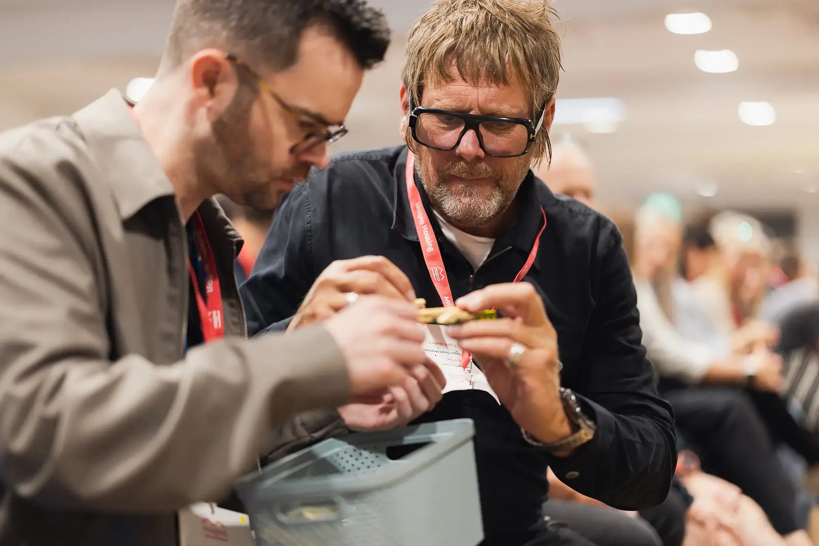 Two male colleagues concentrating together on a practical task during a corporate away day event in Somerset