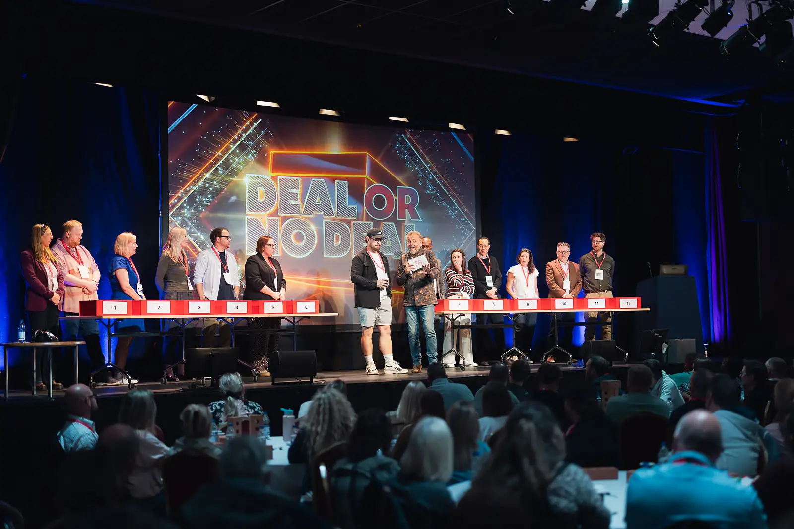 Line of colleagues on stage taking part in an interactive game show activity at a corporate event in Somerset