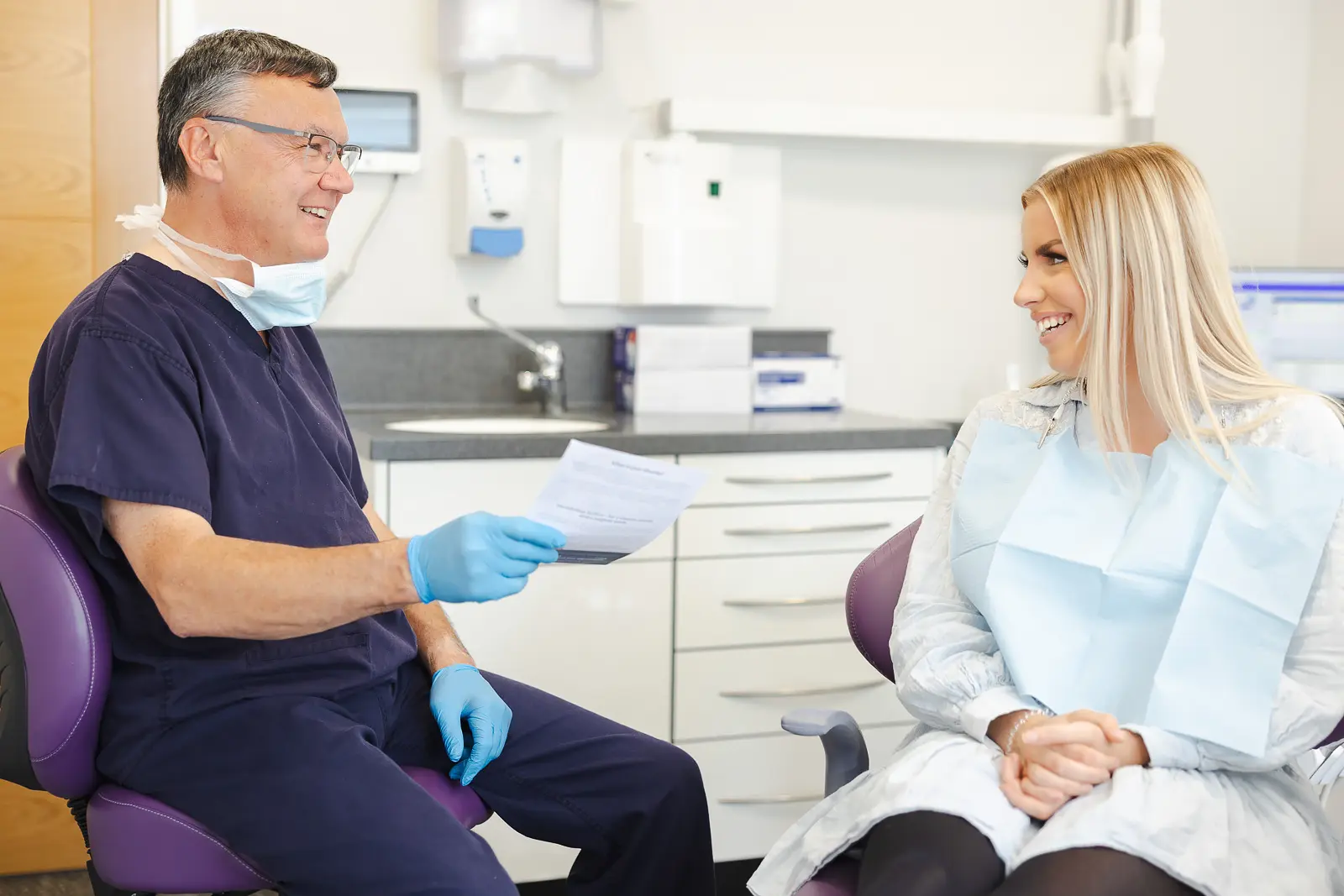 Dentist speaking with a patient during a branding photography shoot for a Bournemouth dental practice.