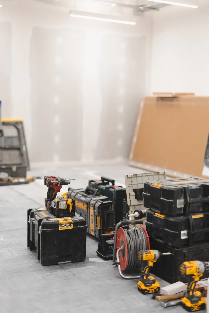 Stack of DEWALT ToughSystem toolboxes inside a newly dry-lined construction room, natural light from window