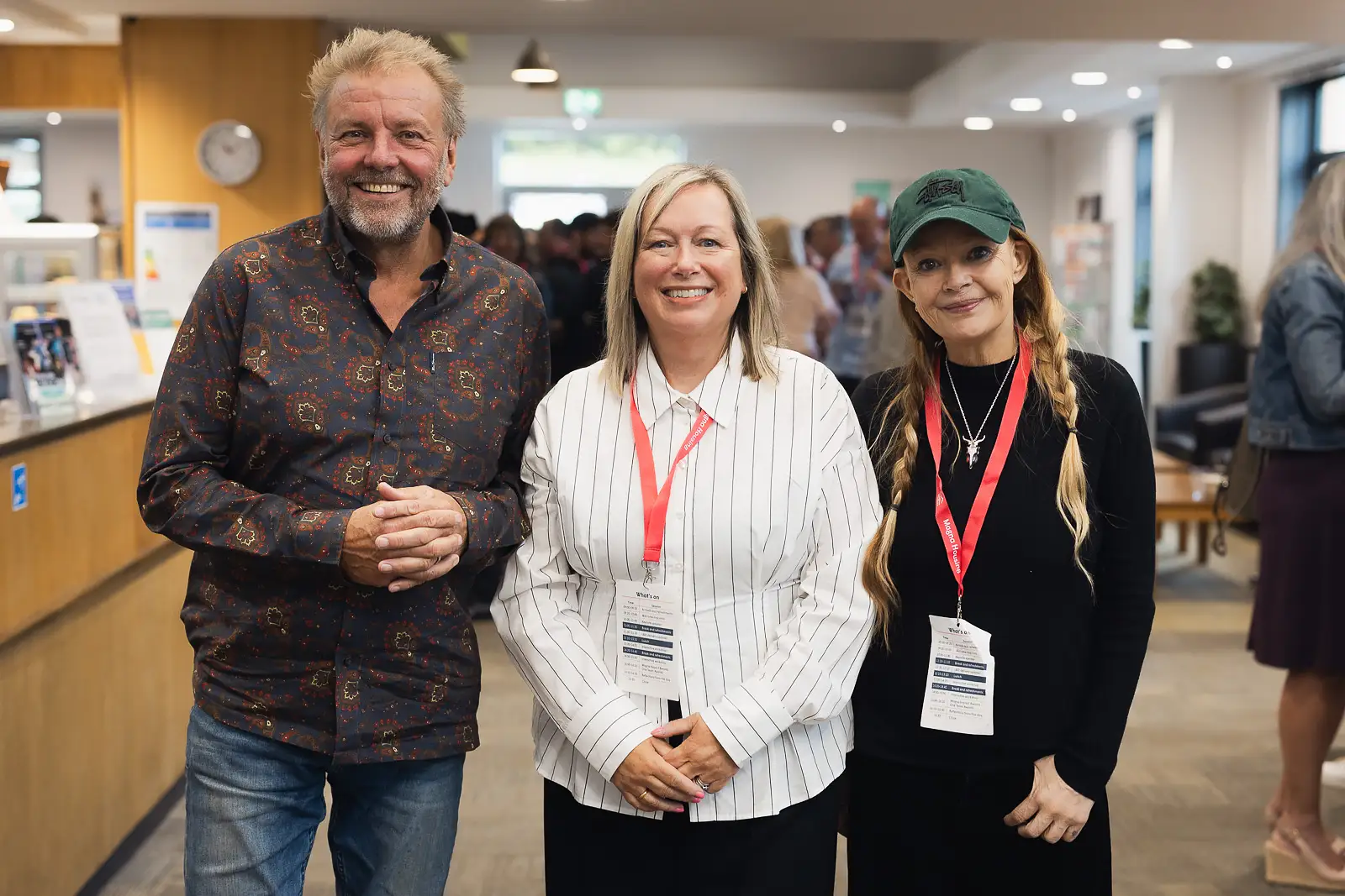 Three event speakers and host smiling together during a break at a corporate away day at Westlands Theatre