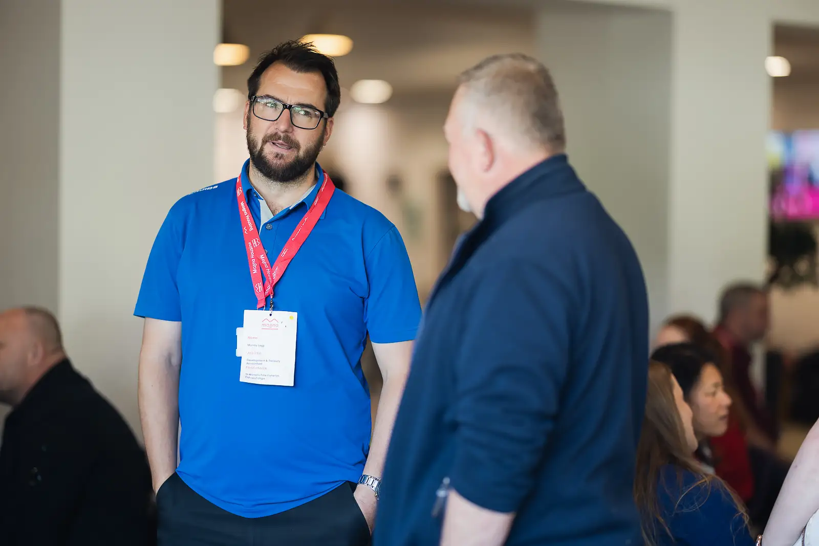 Two male colleagues in informal conversation during a break at a corporate away day event in Somerset