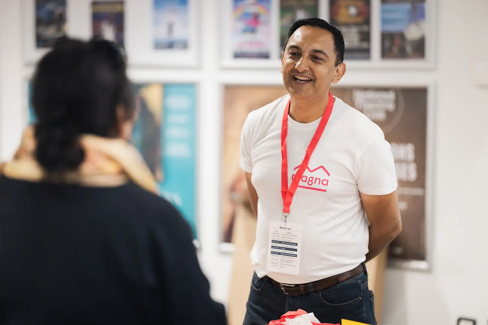 Laughing colleague in branded t-shirt and lanyard during pre-event conversation at Westlands Theatre Somerset