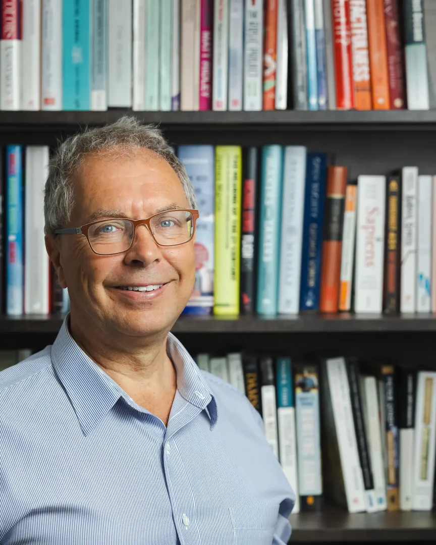 Personal branding portrait of an independent financial advisor in Sandbanks, Poole, photographed beside a bookshelf.