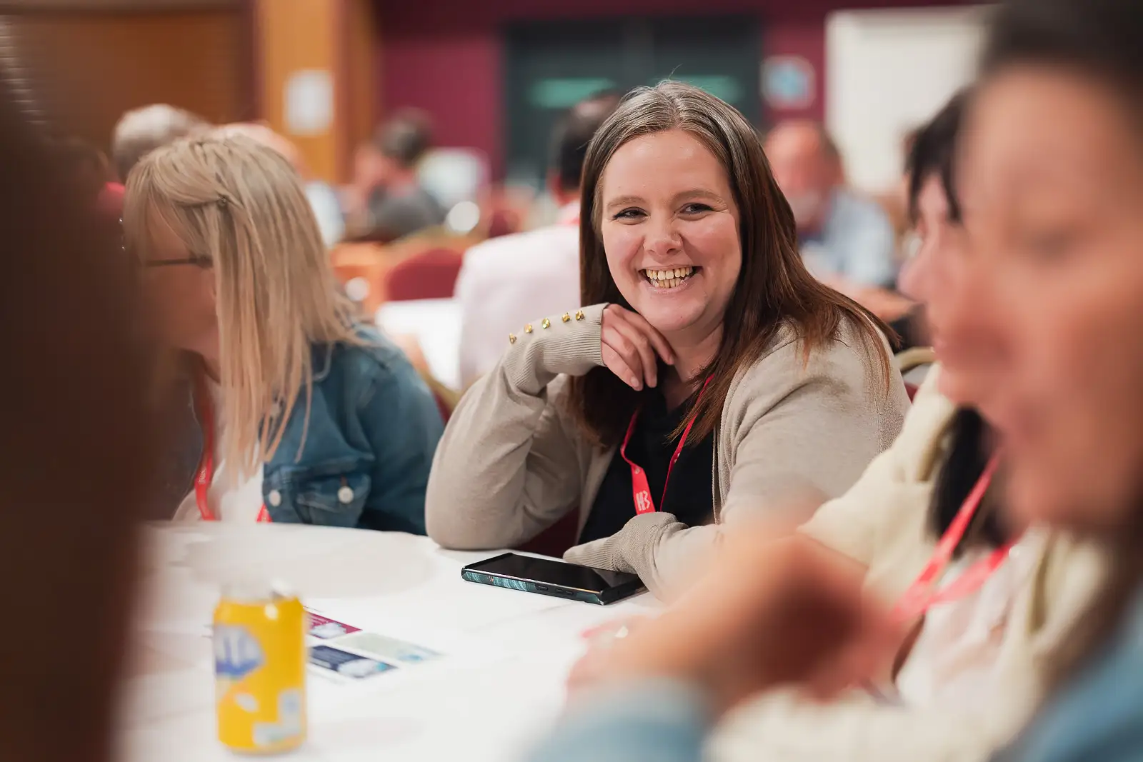 Smiling female delegate leaning on a table during a session at a corporate conference at Westlands Theatre