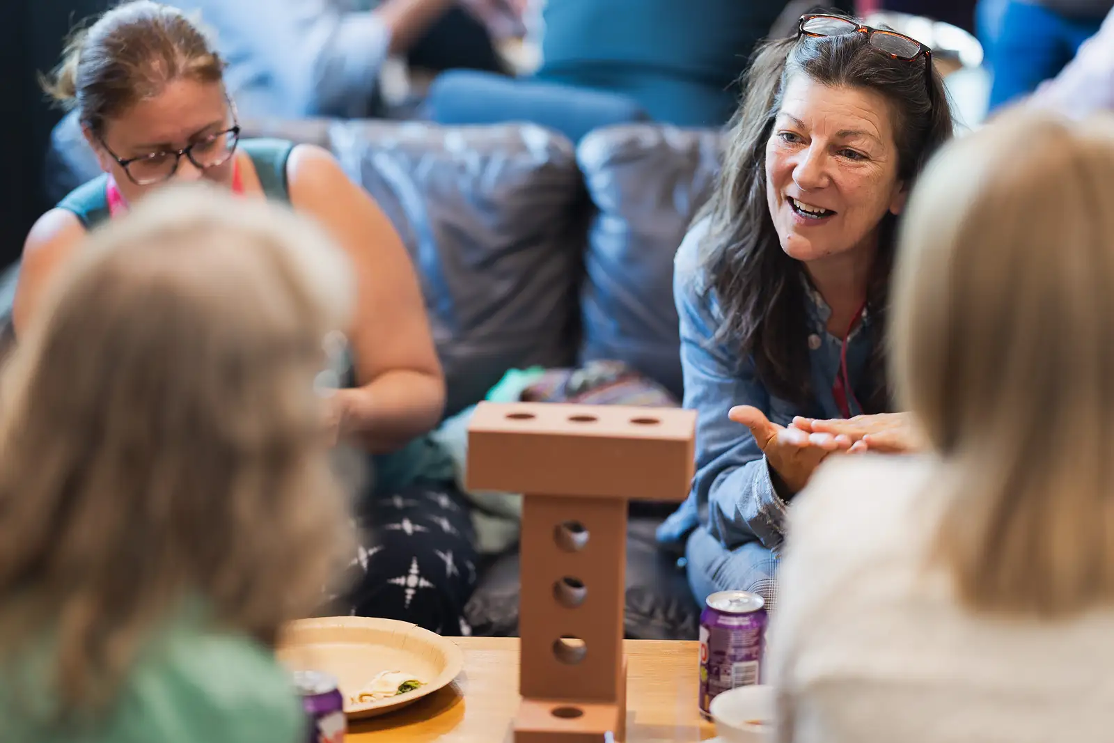 Colleague in relaxed conversation with teammates around a table during a workshop activity at a corporate event