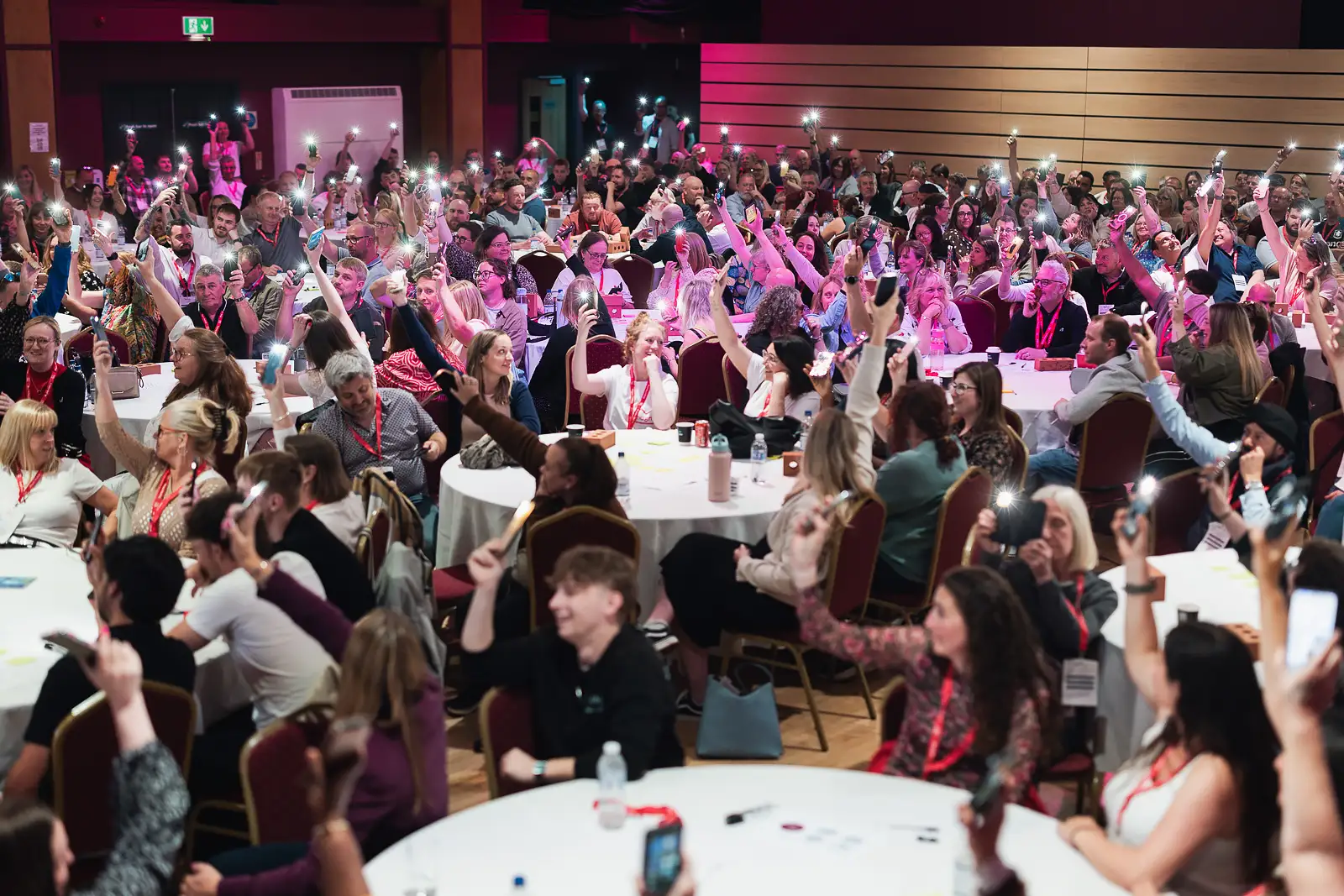 Entire room of colleagues holding up phone lights in a celebratory moment at a corporate away day at Westlands Theatre Somerset