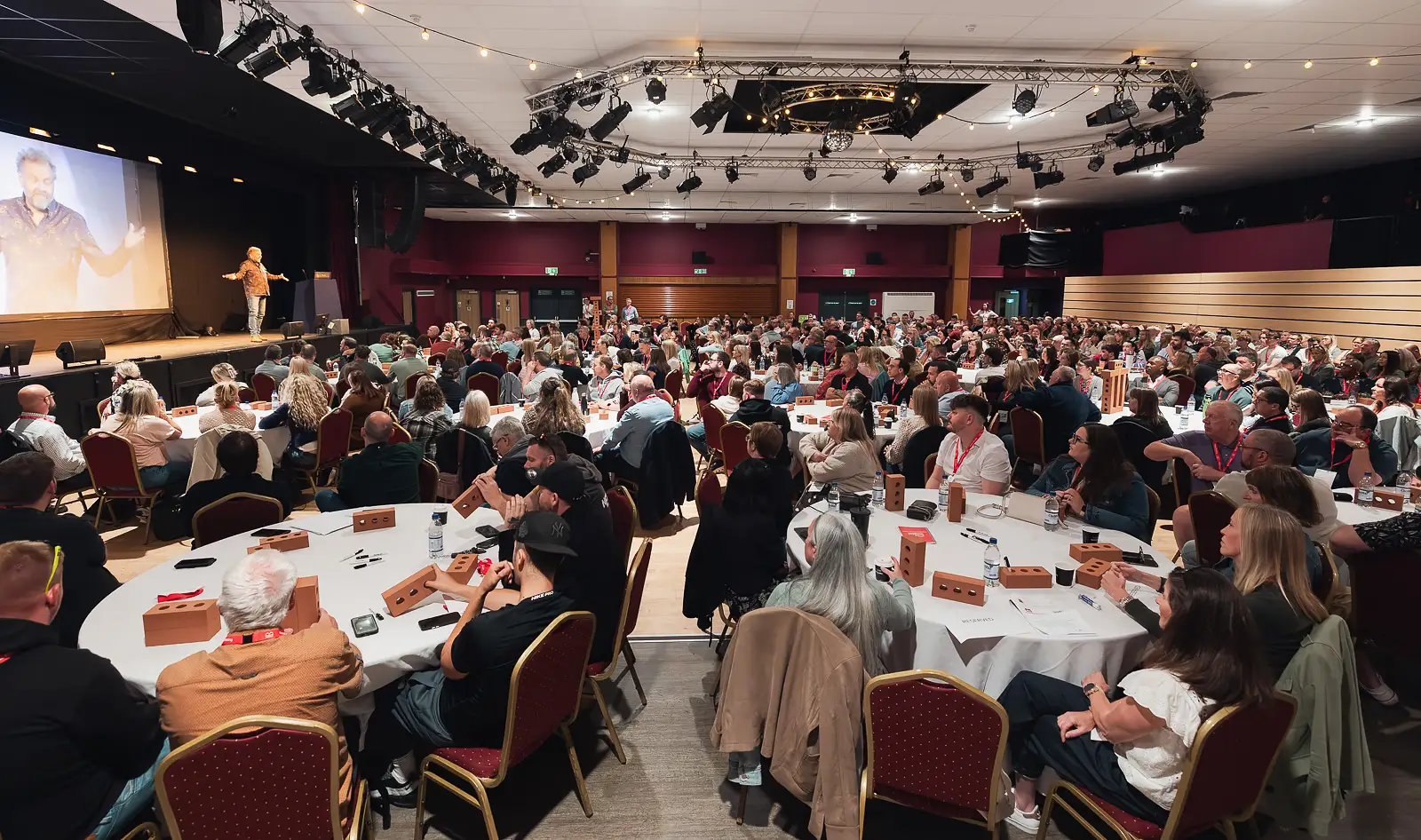 Wide room view of hundreds of delegates seated at round tables during a corporate conference at Westlands Theatre Yeovil