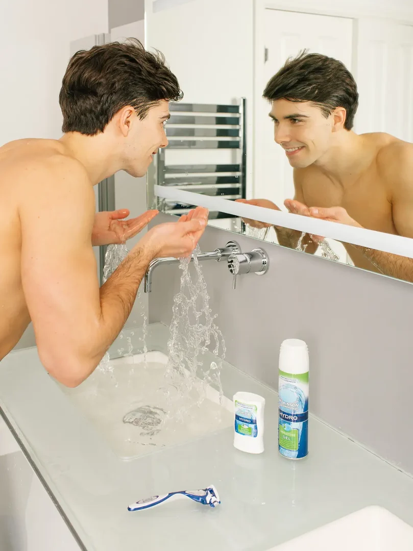 Man rinsing his face and smiling in the mirror, shot for a Bournemouth brand campaign