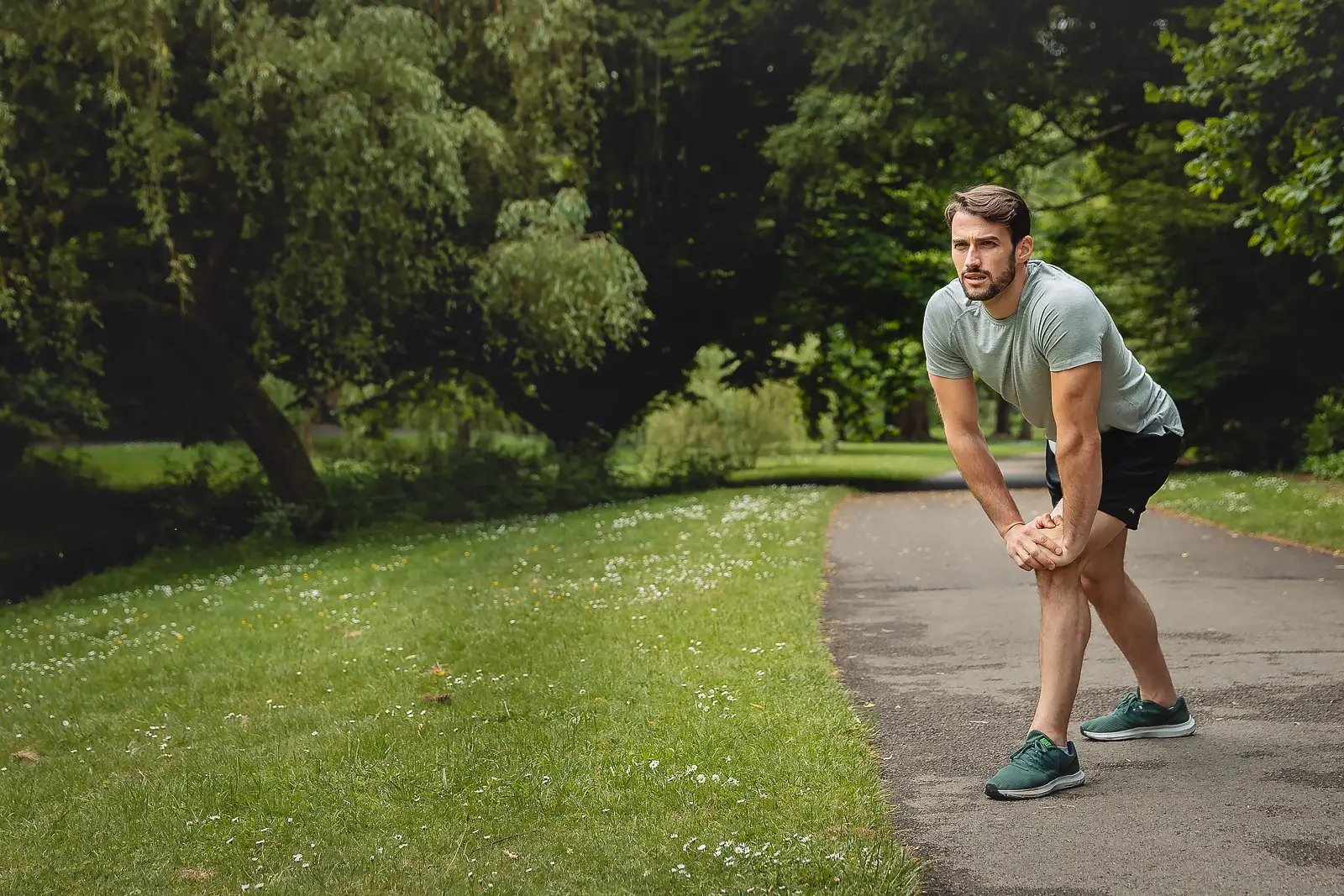 Man resting with hands on his knees after a run in Bournemouth, from a product photography campaign