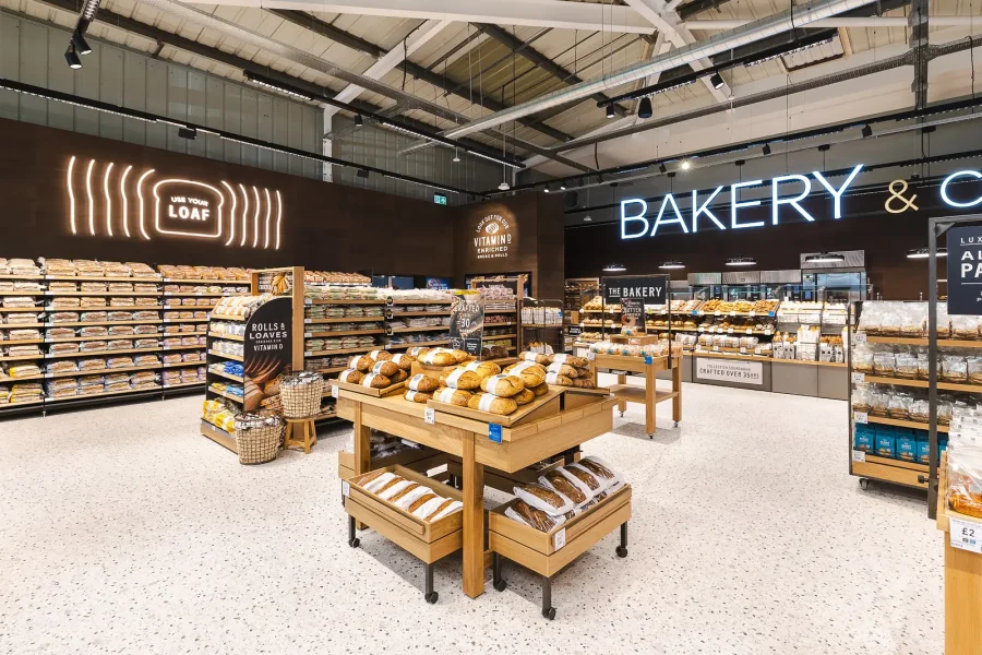 Bakery interior photography showing bread displays, wooden tables and illuminated signage in the Poole food hall.