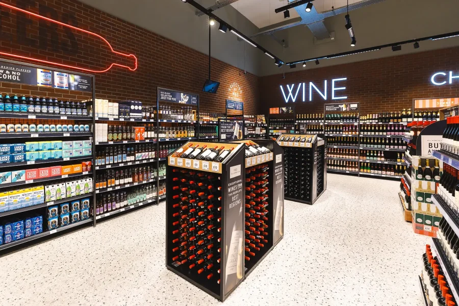 Wine displays beneath illuminated signage, photographed during the retail interior shoot in Poole.