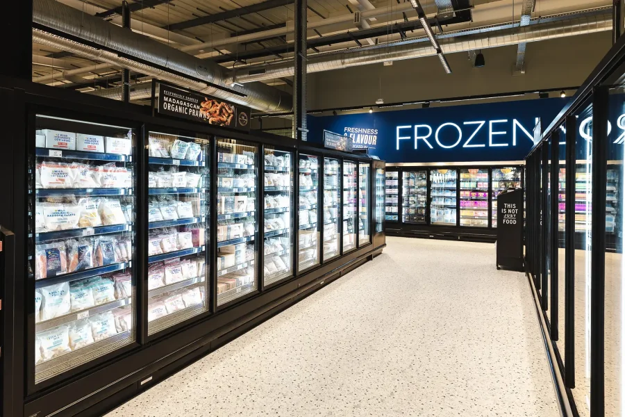 Retail interior photograph of illuminated Frozen signage above glass-fronted cabinets in the Poole food hall.
